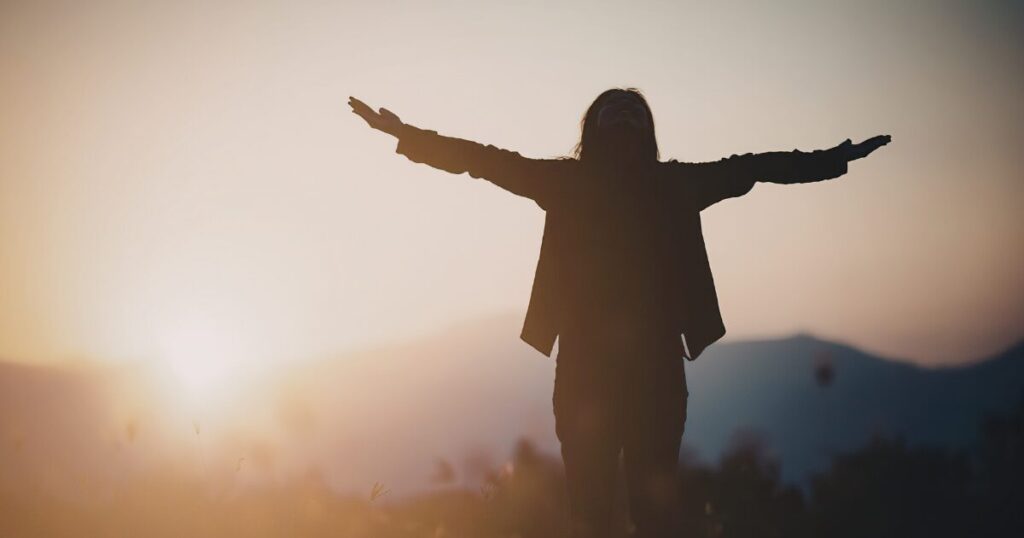 両手を広げて喜ぶ女性
