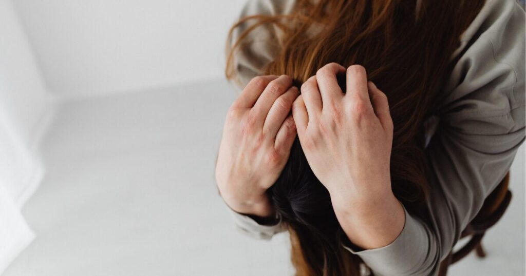 頭を抱えて悩んでいる